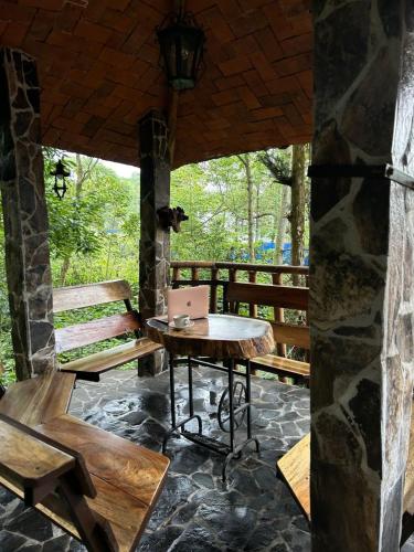 a patio with a table and a bench on a porch at Casa Machtiani in Cedro
