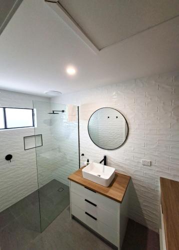 a bathroom with a sink and a glass shower at No 3 Lakeside in Mulwala