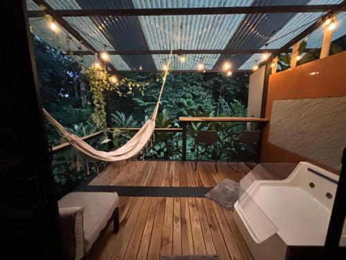 a hammock on a deck with a bath tub at River Paradise Cabin with Private Jacuzzi in Fortuna