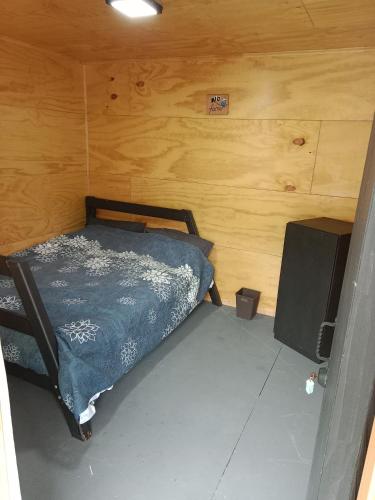 a small bedroom with a bed and a speaker at Hostal Egaña 228 in Puerto Montt
