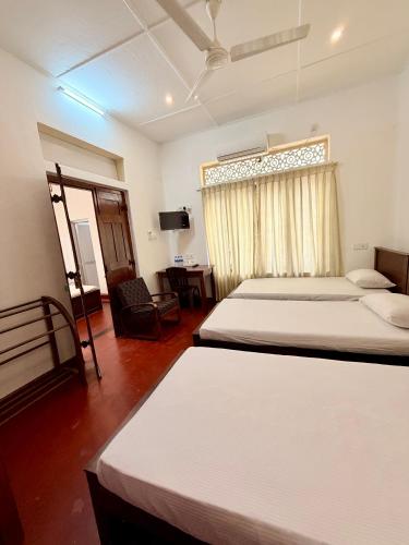 a hotel room with two beds and a window at Bon Voyaage Villa in Trincomalee