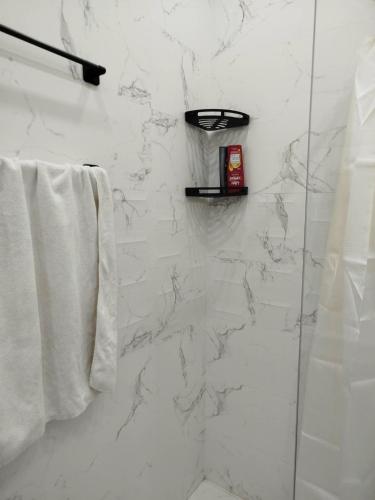 a white bathroom with a shower and a towel at Primavera Marmara Hamam sousse in Hammam Sousse