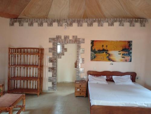 a bedroom with a bed and a crib at Nyantanto Eco Lodge in Gunjur