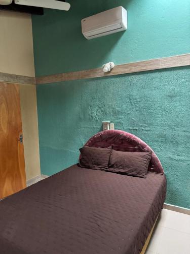 ein Schlafzimmer mit einem Bett und einer grünen Wand in der Unterkunft Residencia Las Lomitas in San Lorenzo de la Frontera