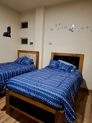 two beds sitting next to each other in a bedroom at Lily's Apartamentos in Cochabamba