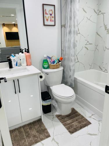 ein Badezimmer mit Toilette, Badewanne und Waschbecken in der Unterkunft Ivey Homes in Edmonton