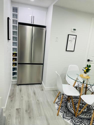 a kitchen with a stainless steel refrigerator and a table and chairs at Ivey Homes in Edmonton
