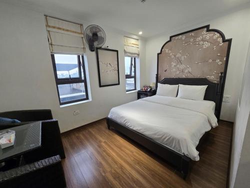 a bedroom with a large bed with a large headboard at Nhật Tân Hotel Hà Nội - Lê Trọng Tấn in Hanoi