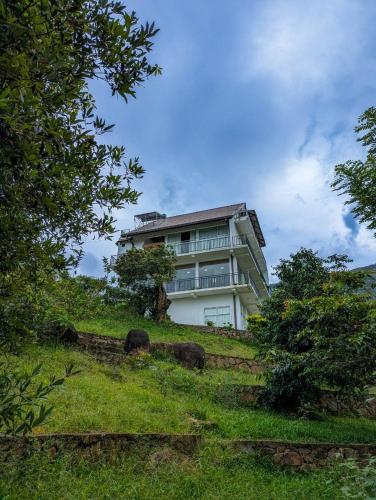a building on top of a grassy hill at Tranquil Edge Villa in Haputale