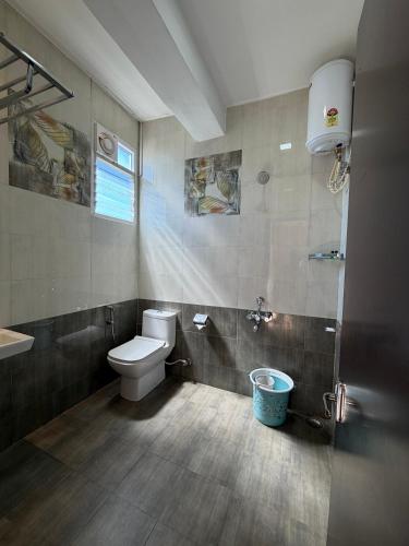 a bathroom with a toilet and a sink at Vanam Holidays in Ooty