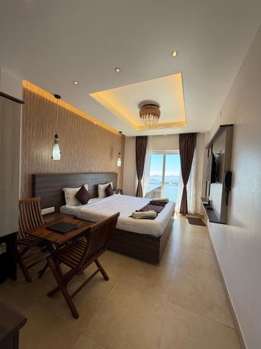 a bedroom with a large bed and a table and chairs at Vanam Holidays in Ooty