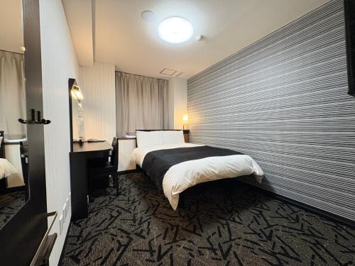 a hotel room with a bed and a window at APA HOTEL Fukushima Ekihigasi in Fukushima