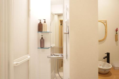 a bathroom with a shower and a sink at Kimono Hotel Himeji 着物宿 in Himeji