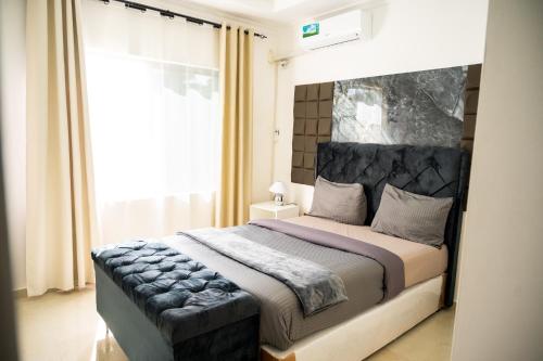 a bedroom with a large bed with a large window at 2nd street ibex Apartment in Lusaka