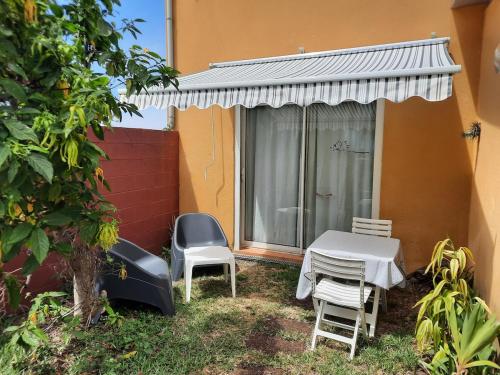 a table and chairs sitting outside of a house at Leu Cosy Coco in Saint-Leu