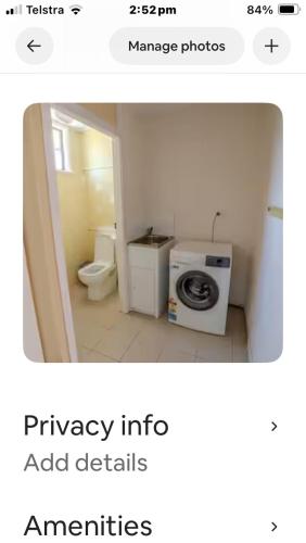 a bathroom with a toilet and a washing machine at Beach house in Hallidays Point