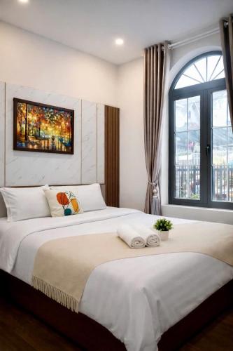 a bedroom with a large bed and a window at Lumi Home Đà Lạt in Da Thanh