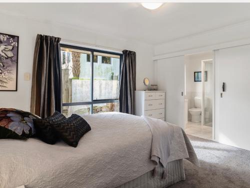 a bedroom with a bed and a large window at 3 bedroom home Tranquil Views in Rotorua