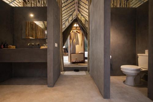 a bathroom with a toilet and a sink and a mirror at Tamu Koh Rong in Koh Rong Island