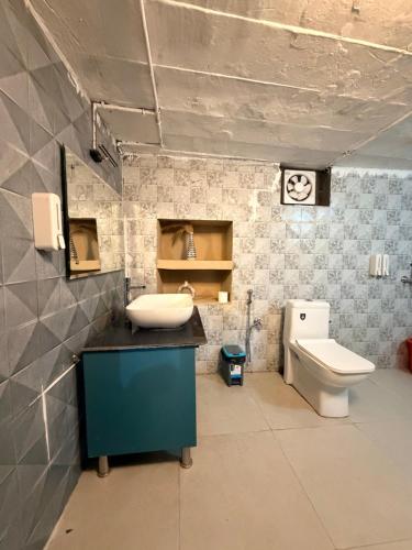 a bathroom with a sink and a toilet at NAMOH e VIRAASAT in Chopta