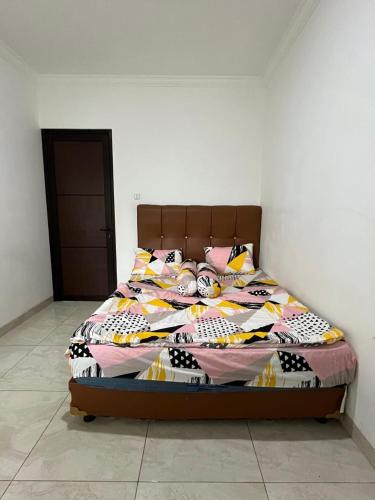 a bedroom with a large bed with colorful pillows at Villa Brown Cisarua in Paragajen