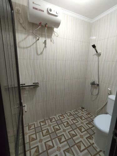 a bathroom with a shower and a toilet at Villa Brown Cisarua in Paragajen