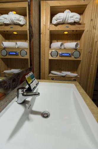a bathroom with a tub and a sink and towels at Hotel Alexandros in Doxato