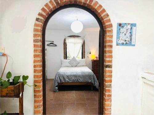 an archway leading into a bedroom with a bed at Hostal Corazón de Allende in San Miguel de Allende