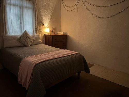 a bedroom with a bed and a window at Hostal Corazón de Allende in San Miguel de Allende