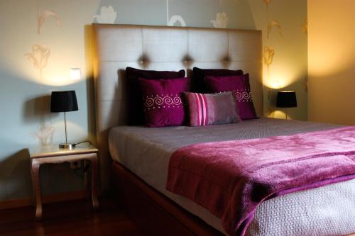 カニコにあるGarajau Cliffのベッドルーム1室(紫色のシーツと枕が備わる大型ベッド1台付)