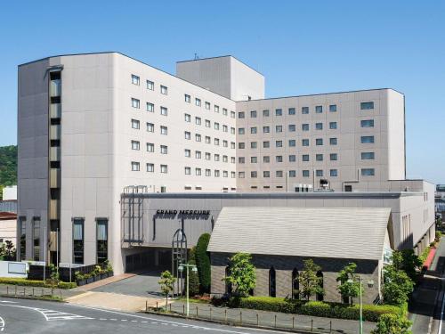 a large white building with a road in front of it at Grand Mercure Nara Kashihara in Kashihara