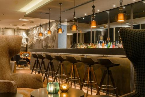 a bar in a restaurant with stools at Motel One Manchester-Royal Exchange in Manchester