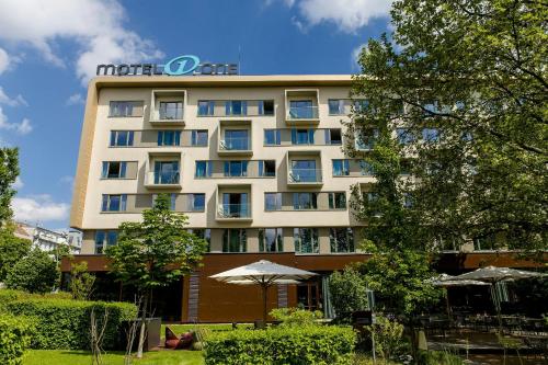 a hotel building with an umbrella in front of it at Motel One Wien-Prater in Vienna