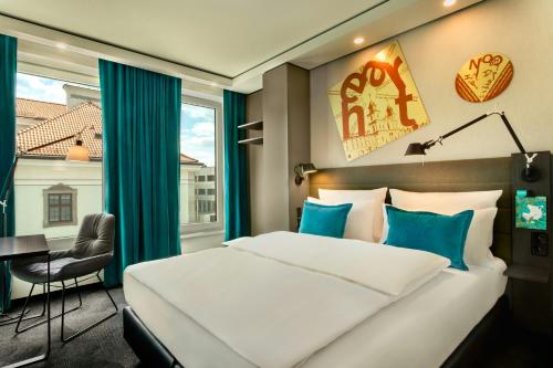 a bedroom with a bed and a desk and a window at Motel One Warsaw-Chopin in Warsaw