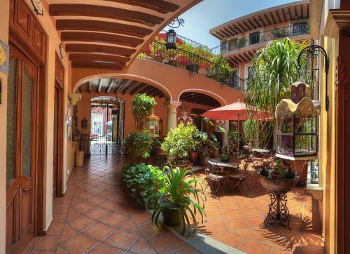 un patio con plantas y mesas y un edificio en Hotel Boutique Parador San Miguel Oaxaca, en Oaxaca City