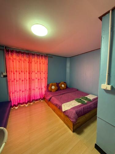 a bedroom with a bed with a teddy bear on it at KohLibong Beach House Homestay in Ban Batubute
