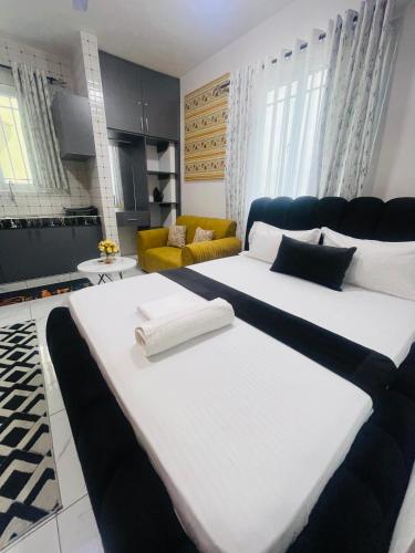 two large white beds in a room at Mo Homes studio in Mombasa