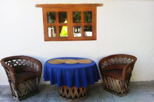 a table and two chairs with a blue table and a window at La Casona Breakfast & Wellness Center in Temascaltepec de González
