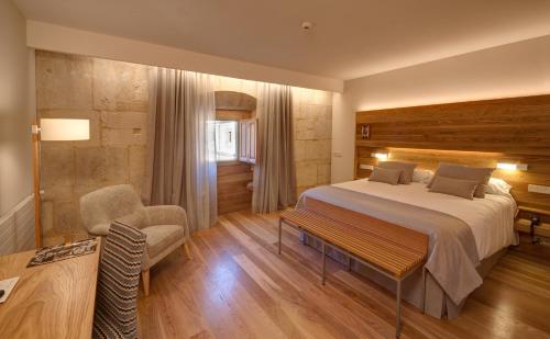 a bedroom with a bed and a desk and a chair at Hotel Real Colegiata San Isidoro in León