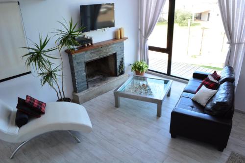 a living room with a couch and a fireplace at Calas del Diablo in Punta Del Diablo