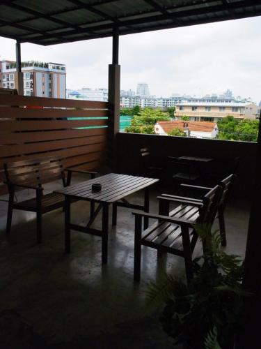 a picnic table and bench on a balcony with a view at VX The Fifty in Bangkok
