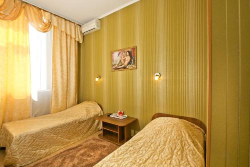 a hotel room with two beds and a table at Hotel Boyard in Ussuriysk