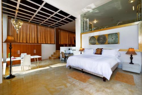 a bedroom with a large white bed and a desk at Villa Buah in Senggigi 