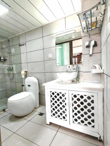 a bathroom with a toilet and a sink and a mirror at In Spring Country Courtyard in Lijiang in Lijiang
