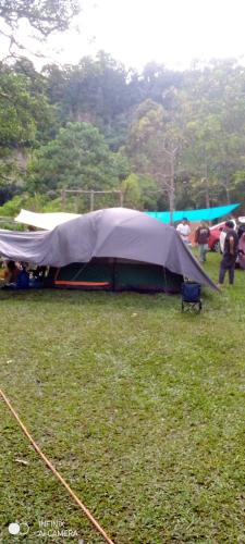 a tent in a field in the rain at Sikumbang camp in Bukittinggi