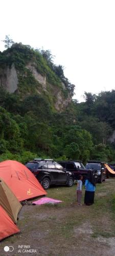a group of tents and cars parked in a field at Sikumbang camp in Bukittinggi