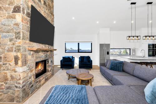 a living room with a couch and a fireplace at Rawson Retreat - Spa, EV outlet and Premium Luxury in Jindabyne