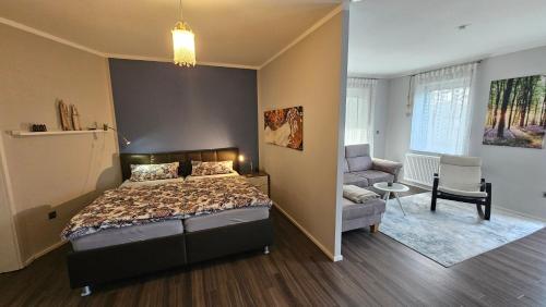a bedroom with a bed and a couch and a chair at Ferienwohnung Werraglück in Eschwege