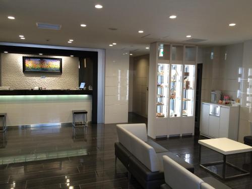 a lobby with a waiting room with a couch and a table at Hotel Mets Nagaoka in Nagaoka