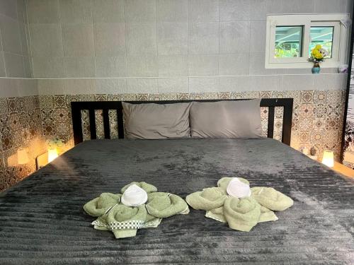 three stuffed animals are sitting on a bed at House & Spa Tropical Home with Private Jacuzzi Koh Phangan in Ko Phangan